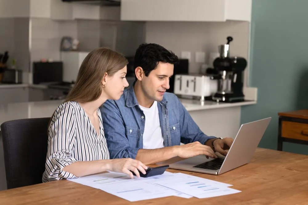 Haushaltsbudget Mann und Frau sitzen am Tisch mit Computer und Taschenrechner